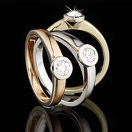 Goldene Verlobungsringe mit Edelsteinen auf dunklem Hintergrund