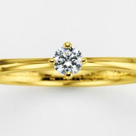 Goldener Verlobungsring mit einem Edelstein auf weißem Hintergrund